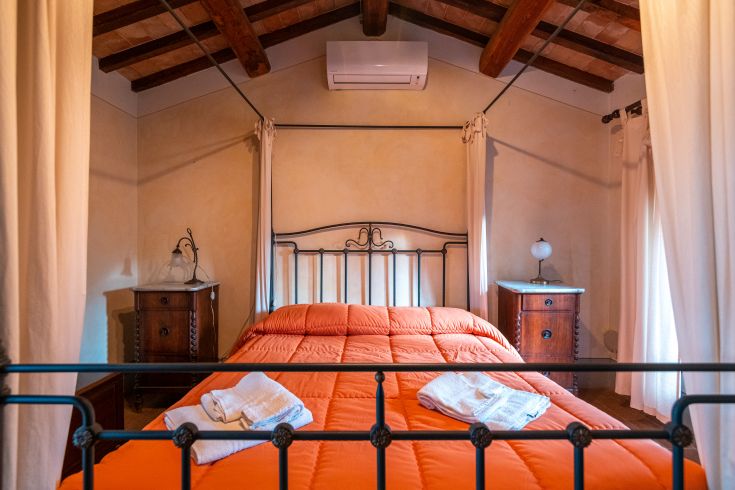 Geräumiges Doppelzimmer mit einfacher Einrichtung und Holzdetails, perfekt für einen ruhigen Aufenthalt.