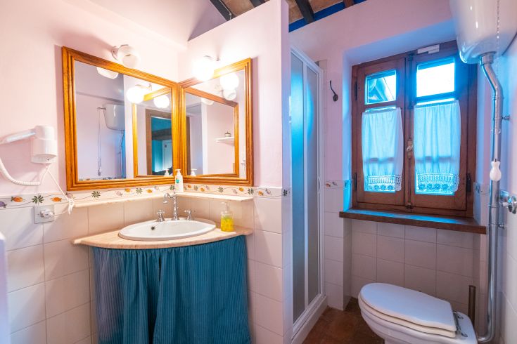 Helles Badezimmer mit Möbeln aus hellem Holz und keramischen Oberflächen. Ein einfaches und einladendes Ambiente.