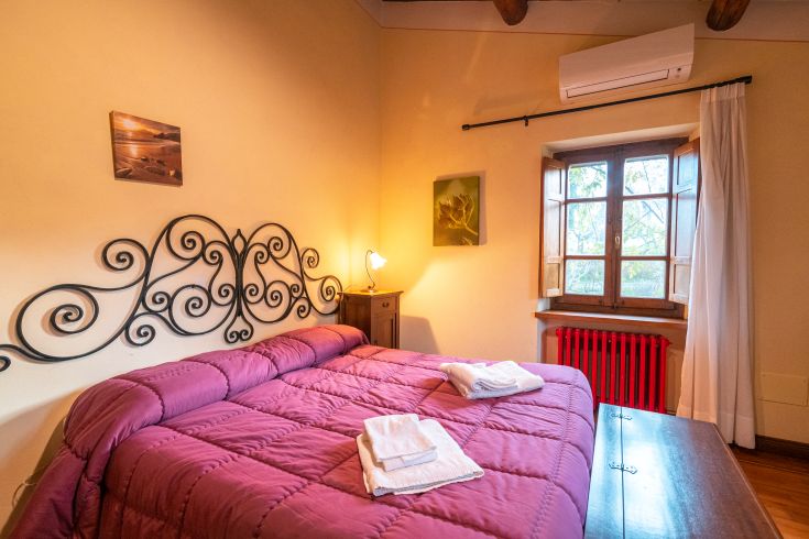 Bequemes Zimmer mit Doppelbetten, warmem Licht und einfacher Einrichtung. Perfekt für einen ruhigen Aufenthalt.