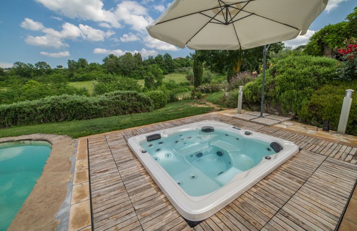 Ein Whirlpool, der in einer natürlichen Umgebung liegt, umgeben von ruhigem Grün, ideal zum Entspannen.