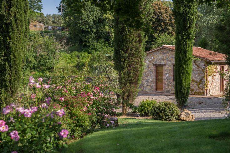 Eine ruhige Szene mit einem Steingebäude, das von üppigem Grün und Blumen umgeben ist, das die Ruhe der Natur verkörpert.