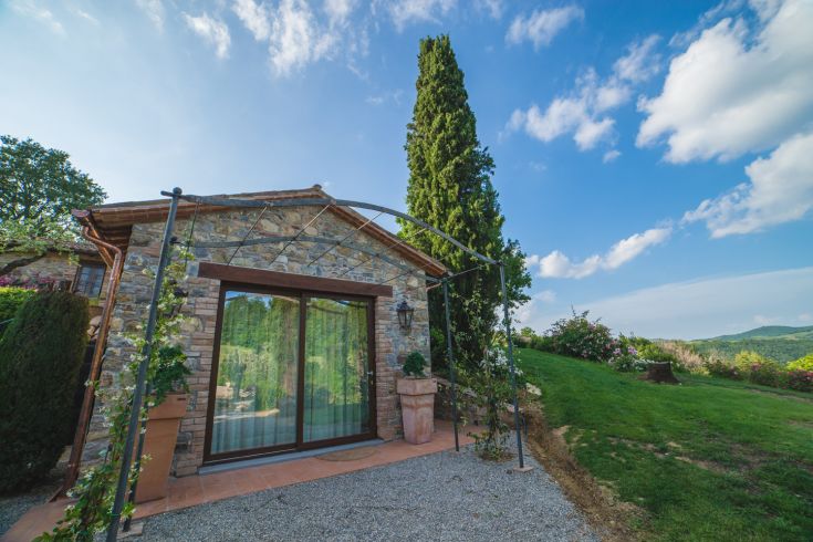 Ein umbrisches Bauernhaus, umgeben von Grün, mit einem schlichten und funktionalen Design.