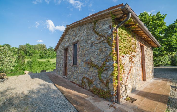 Ein Steingebäude in einem grünen Gebiet, ideal für Freizeitmomente in der Natur.
