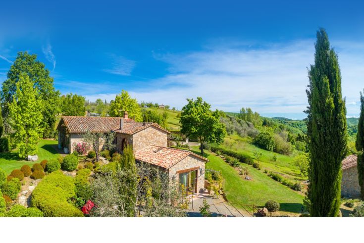 Ein Gebäude, umgeben von Grün, Bäumen und Pflanzen, ideal für entspannende Momente im Freien.