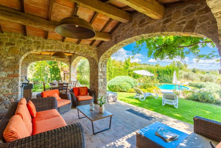 Ein ruhiger Außenbereich mit Blick auf den Pool und den Garten. Ein perfekter Ort zum Entspannen.