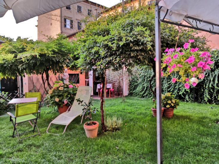 A peaceful area in a garden, featuring green plants and simple furniture for relaxation.