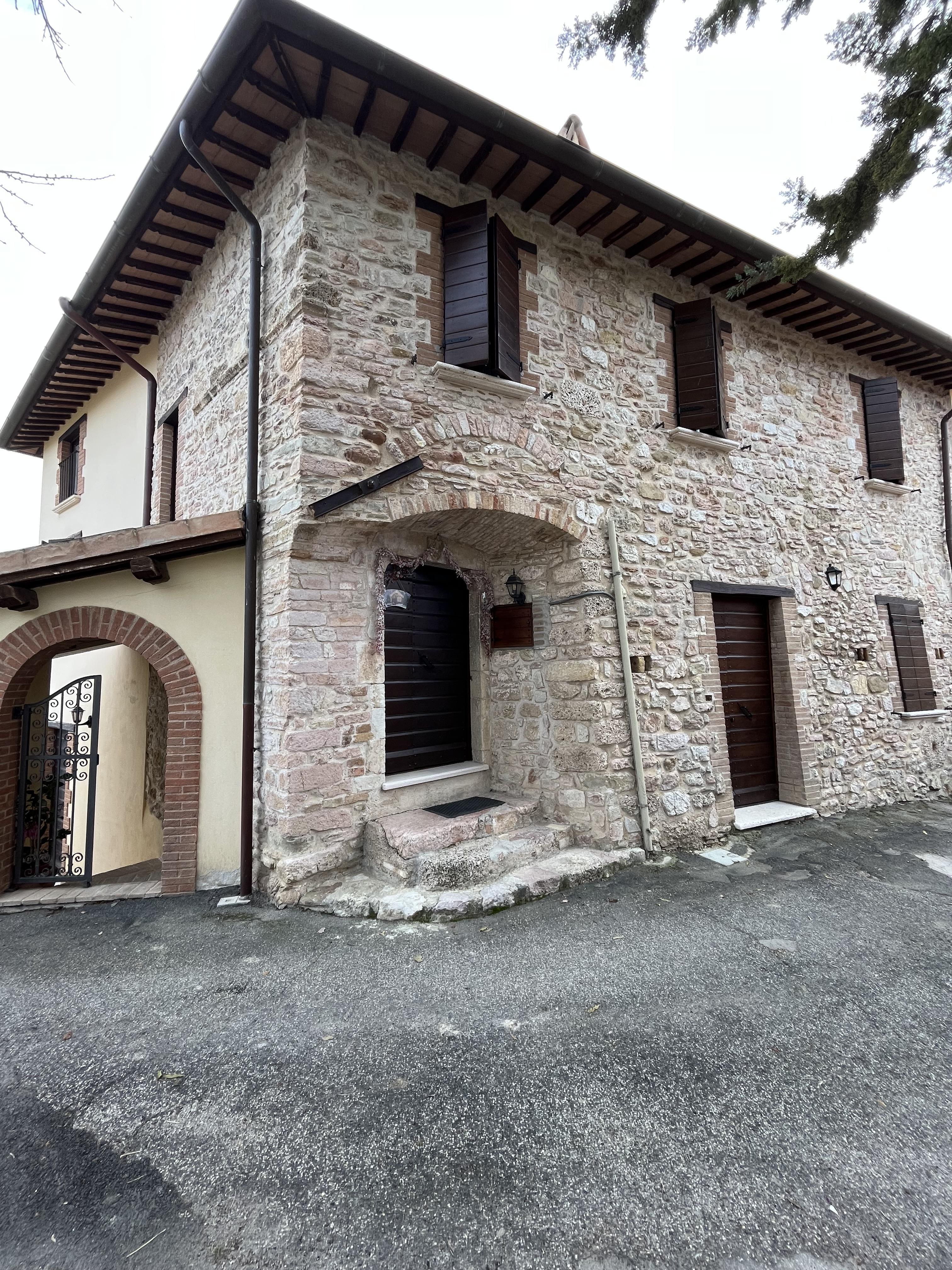 Edificio in pietra con un ingresso semplice e dettagli rustici, immerso in un contesto naturale.