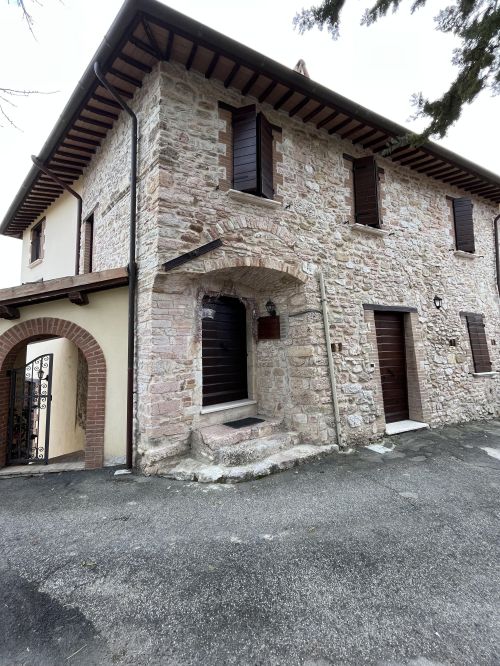 Steingebäude mit einfachem Eingang und rustikalen Details, umgeben von einer natürlichen Umgebung.