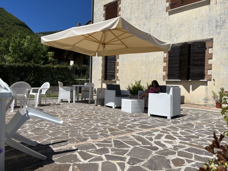 A sunny terrace in the countryside with white sofas, a perfect place for outdoor relaxation.