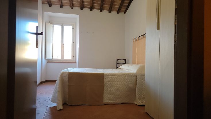 Chambre simple et accueillante, parfaite pour se détendre, avec une fenêtre et un mobilier minimaliste.