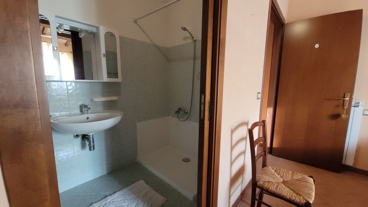 Chambre confortable avec salle de bain privée, adaptée pour 2 à 4 personnes. Mobilier simple et cadre bien entretenu.