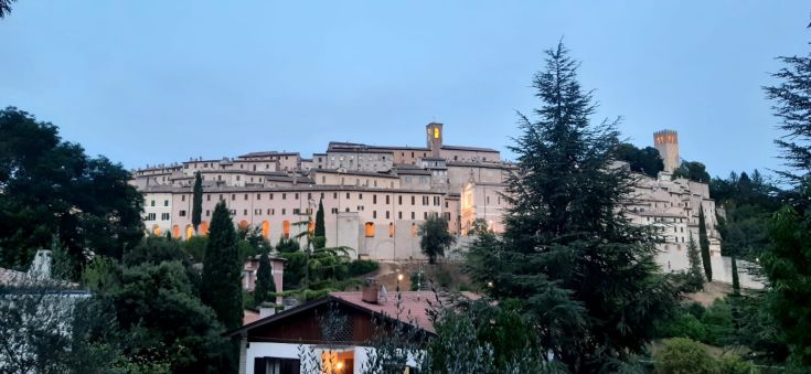 Une scène d'un ancien bâtiment entouré d'arbres en fin d'après-midi.