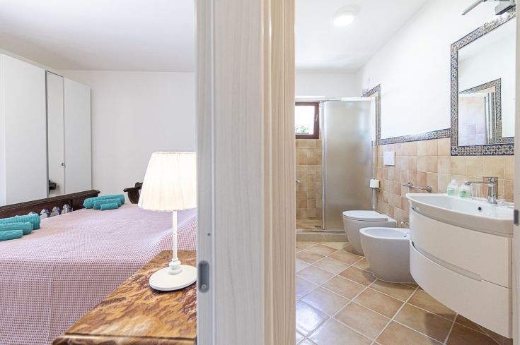 Ambiance simple avec une chambre double et une salle de bain fonctionnelle, idéale pour des moments de détente.
