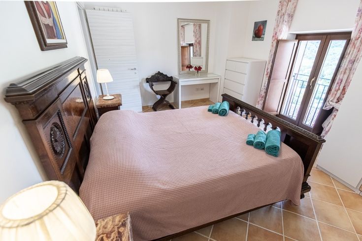 Chambre double confortable avec des meubles en bois et des touches de couleur, bien éclairée et spacieuse.