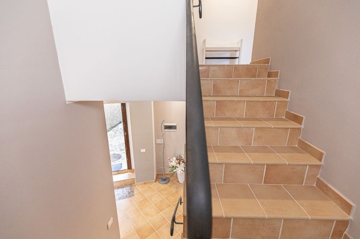 Un environnement confortable avec des escaliers décoratifs et une zone d'entrée, idéal pour se détendre.