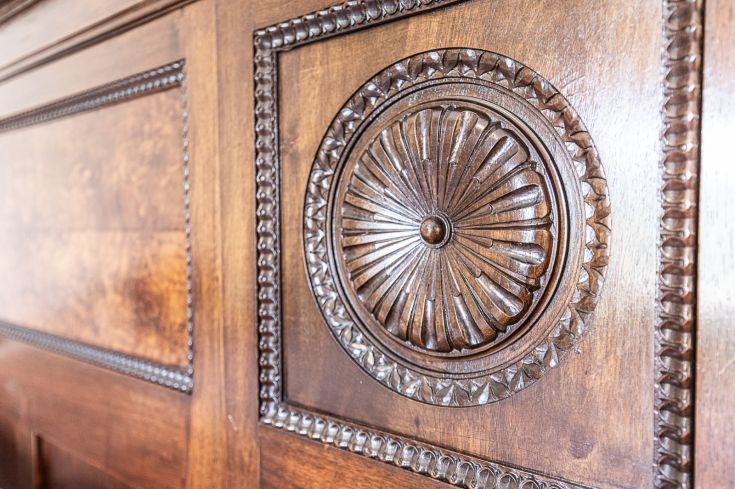 Détail d'un panneau en bois sculpté avec un motif ornemental.