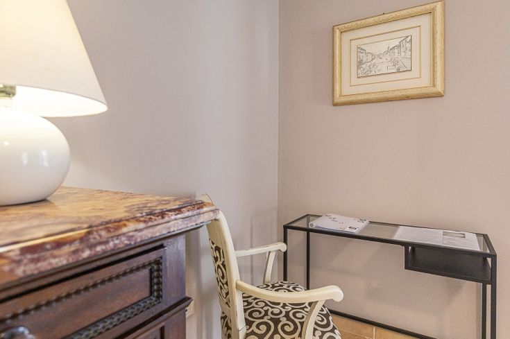 Un espace accueillant dans une pièce avec une lampe, une table décorée et une chaise dans un environnement simple.