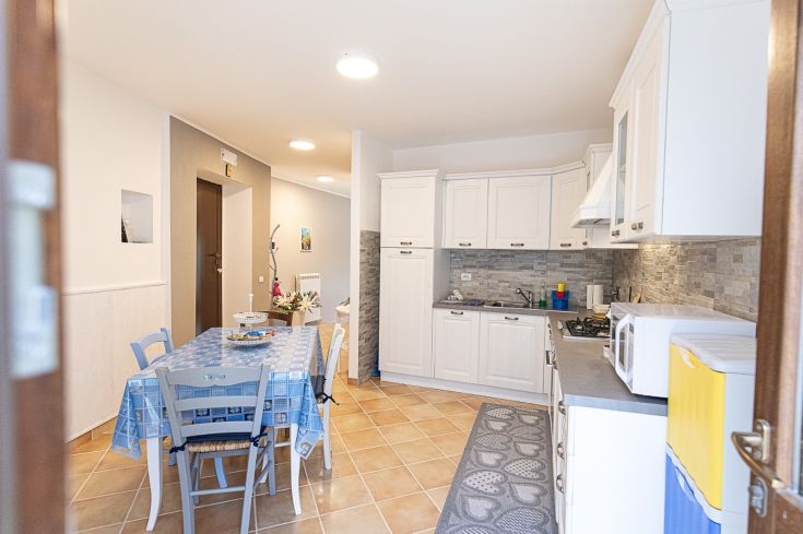 Cuisine rustique, accueillante, équipée d'une table, de chaises et de plusieurs appareils électroménagers fonctionnels.