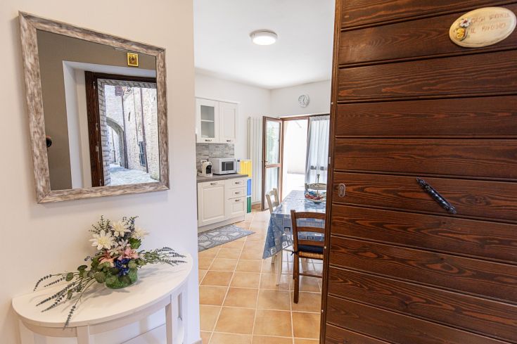 Entrée accueillante menant à des espaces lumineux et des meubles fonctionnels pour un séjour à Nocera Umbra.