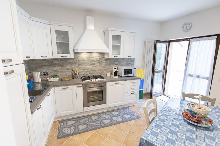 Une cuisine moderne et confortable, équipée d'appareils fonctionnels et d'un coin repas.