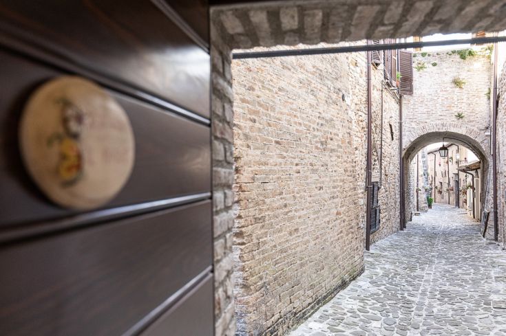 Une ruelle pittoresque avec des arches en pierre dans le centre historique, dotée d'un pavage en pierre.