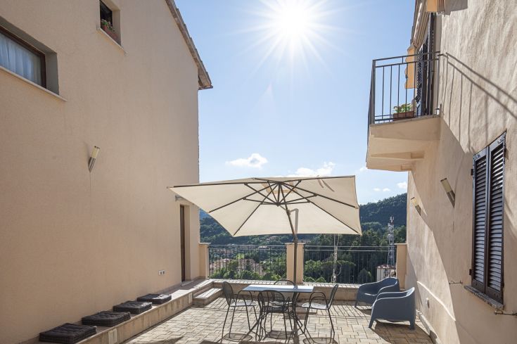Espace extérieur avec une table et un parasol, idéal pour passer des moments tranquilles en plein air.