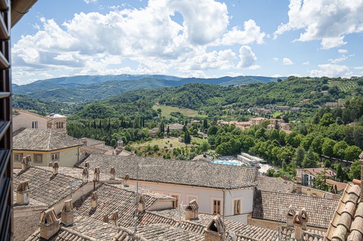 Vue sereine sur des collines douces et des maisons d'une charmante ville ombrienne.