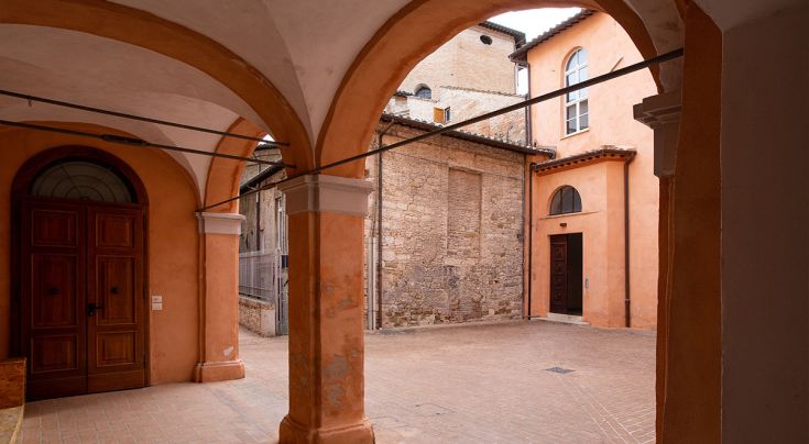 Un tranquillo angolo del centro storico di Perugia, caratterizzato da archi e mattoni storici.