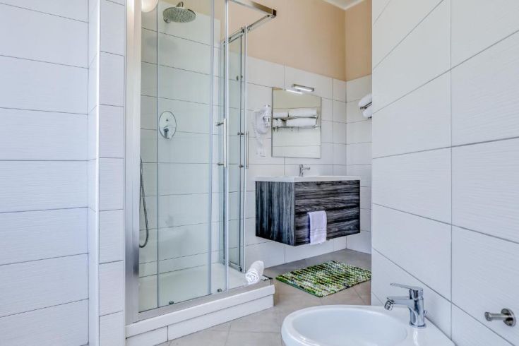 A modern bathroom featuring a shower and sink, characterized by a simple and functional design.