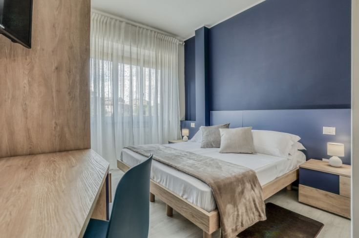 A well-lit room featuring simple blue and light wood furnishings.