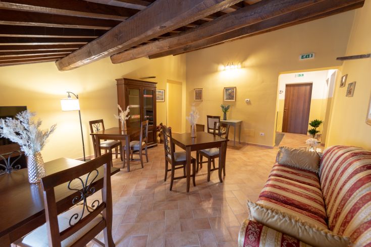 Spazio comune di un hotel, con arredi ben curati e tonalità tenui.