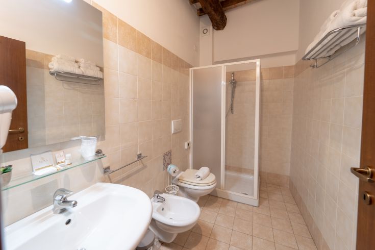 Interno di un bagno ben arredato, dotato di doccia, lavabo e complementi d'arredo contemporanei.