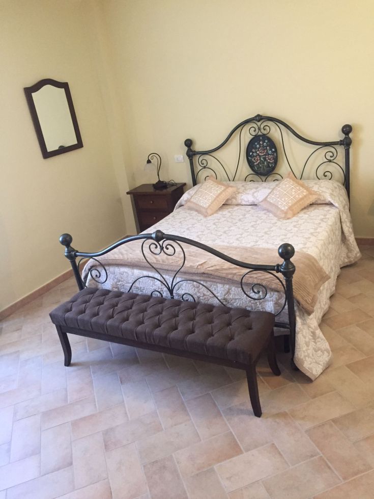 Camera semplice con dettagli curati e letti in metallo, ideale per il relax.