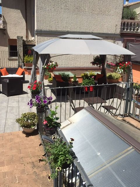 Terrazza tranquilla con pergolato in legno e fiori colorati, perfetta per momenti di relax all'aperto.