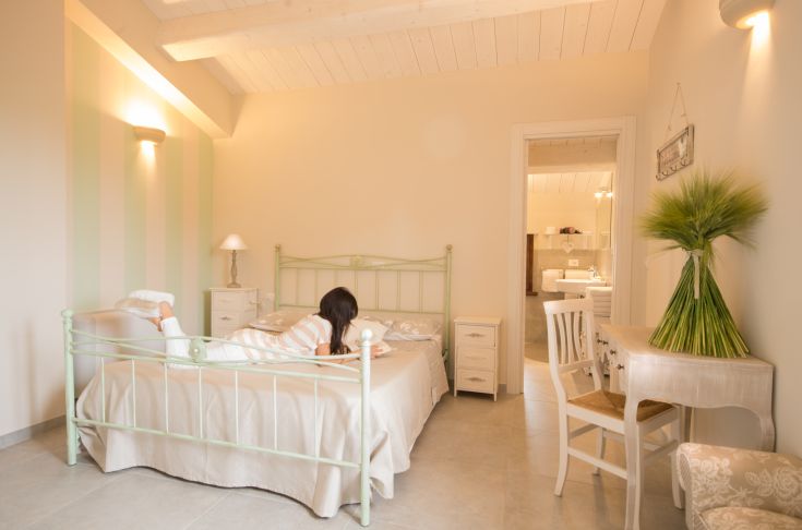 Camera semplice e accogliente in agriturismo, con arredamento in stile shabby e illuminazione naturale.