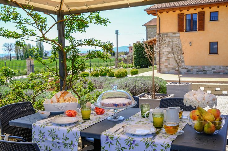 Colazione semplice in un agriturismo circondato da verdi campagne, con panorama sulla natura.