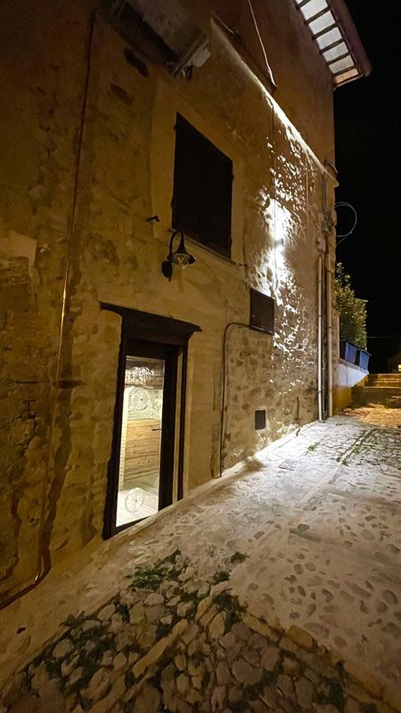 Edificio in pietra, con un'illuminazione tenue, situato in un borgo dell'Umbria.