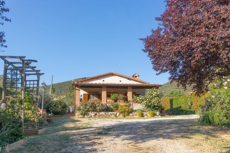 Un edificio immerso nel verde, circondato da un giardino curato con fiori di diversi colori.