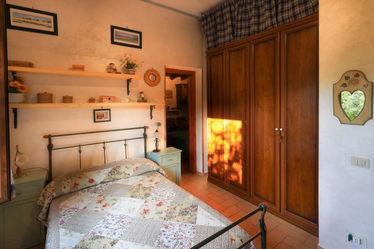 Camera semplice e accogliente con letti in legno, arredi essenziali e luce naturale.