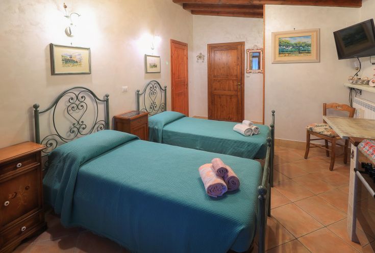 Spazio semplice con letti singoli, arredato in modo sobrio e provvisto di comfort essenziali.