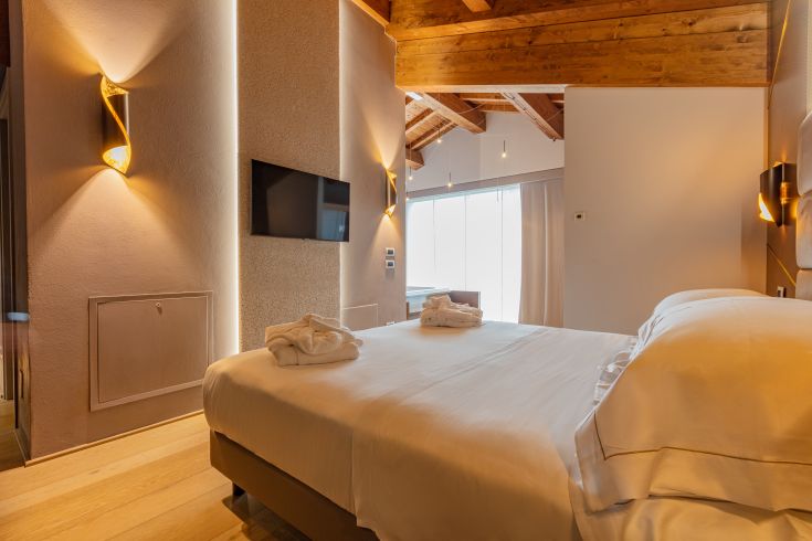 Ein einfaches und gemütliches Zimmer mit sichtbaren Holzbalken und modernen Möbeln, perfekt zum Entspannen.