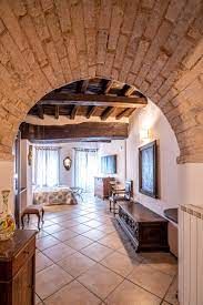 Una camera confortevole in uno stile rustico, caratterizzata da archi in mattoni e un pavimento in piastrelle.