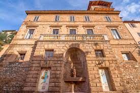 Una facciata in pietra con decorazioni, sotto un cielo azzurro.