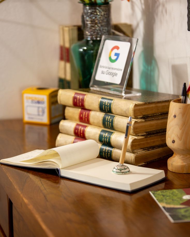 Una scrivania semplice con alcuni libri e un taccuino aperto, in un ambiente rilassato e confortevole.