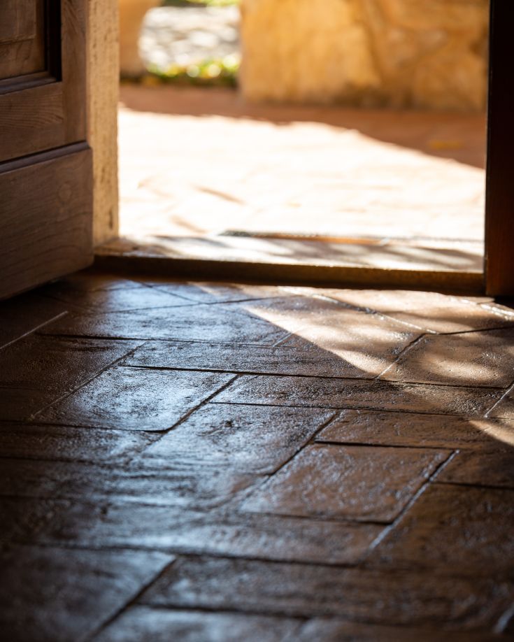 Dettagli del pavimento in cotto che caratterizzano l'ingresso di un edificio rustico.
