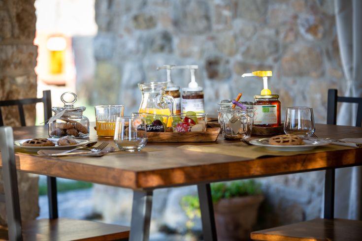 Colazione semplice in un B&B, con dolci freschi, frutta di stagione e marmellate assortite.