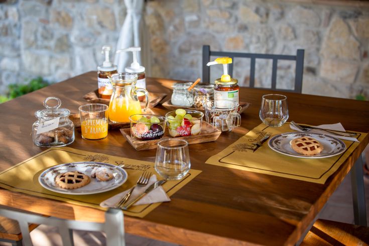 Colazione abbondante con una selezione di dolci fatti in casa e frutta fresca di stagione.