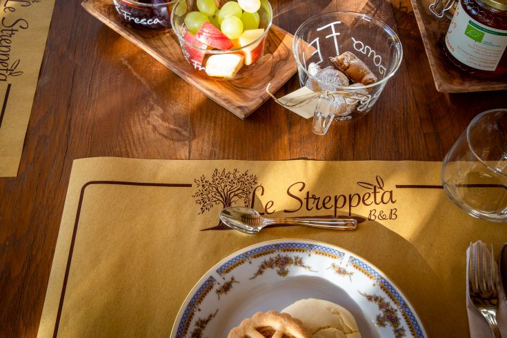 Colazione variegata con dolci fatti in casa e frutta di stagione in un ambiente confortevole.