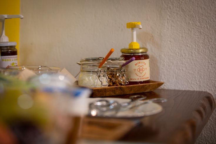 Colazione con miele e confetture in un contesto familiare e accogliente di un B&B.