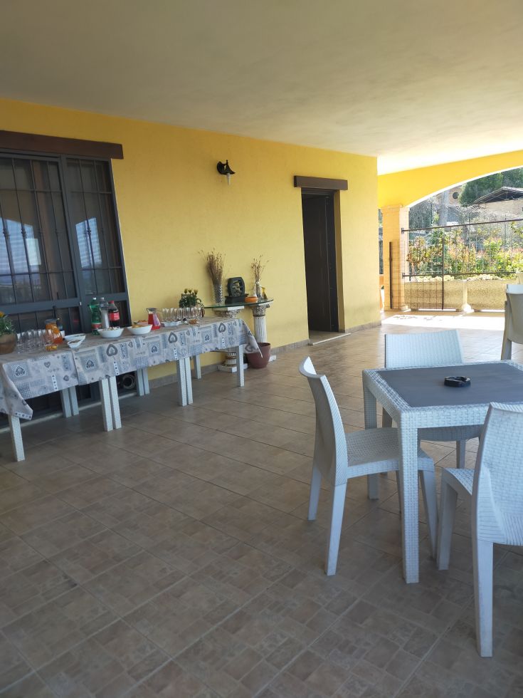 Spacious patio of a B&B, decorated with tables and surrounded by a cozy atmosphere.